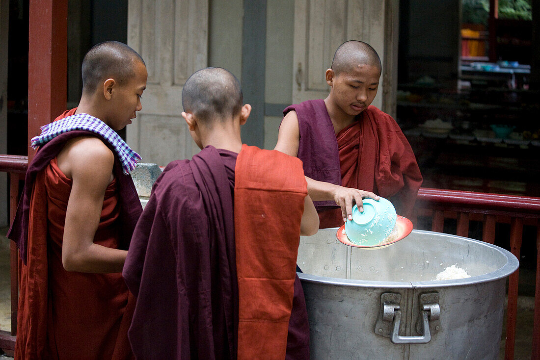 Buddhistische Mönche bei der Essensausgabe von Reis im Mahagandhayon Kloster in Amarapura bei Mandalay, Myanmar, Burma