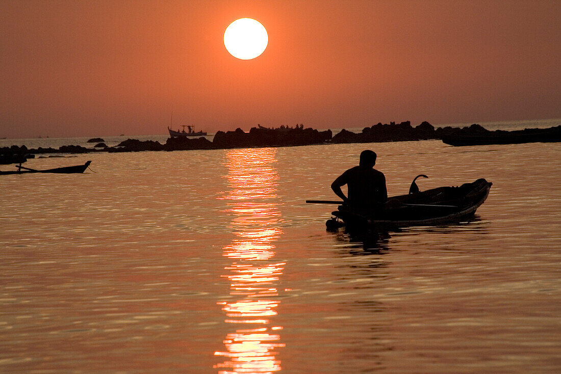 Mann in Paddelboot im Sonnenuntergang in Ngapali Beach, am Golf von Bengalen, Rakhine-Staat, Myanmar, Burma