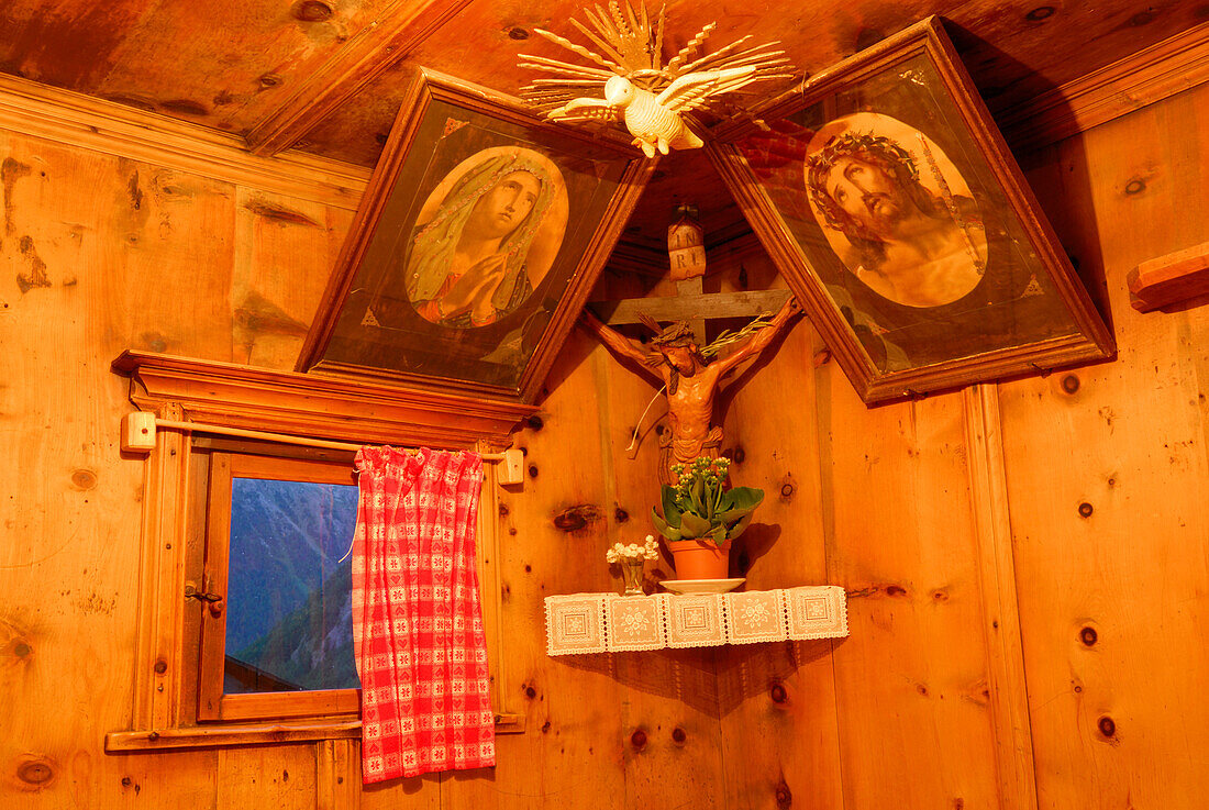 Herrgottswinkel mit Kreuz in der Stube eines Bergbauernhofs, Pfossental, Texelgruppe, Ötztaler Alpen, Südtirol, Italien