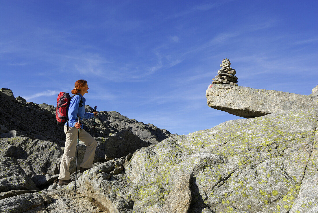 Woman on trail with cairn, Spronser Lake District, Texel range, Oetztal range, South Tyrol, Italy