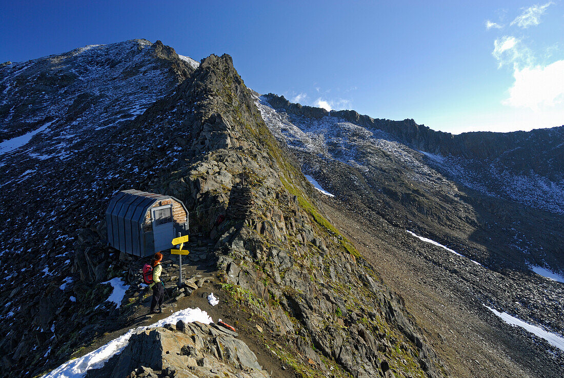 hiker in front of bivouac Gernot-Röhr-Biwak, Hohe Tauern range, National Park Hohe Tauern, Schober range, East Tyrol, Austria