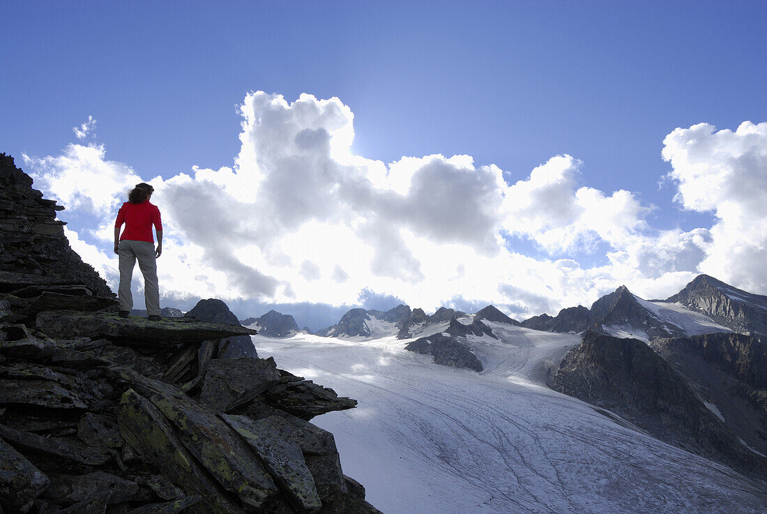 Woman standing on a rock near a glacier, Stubai Alps, Stubai, Tyrol, Austria