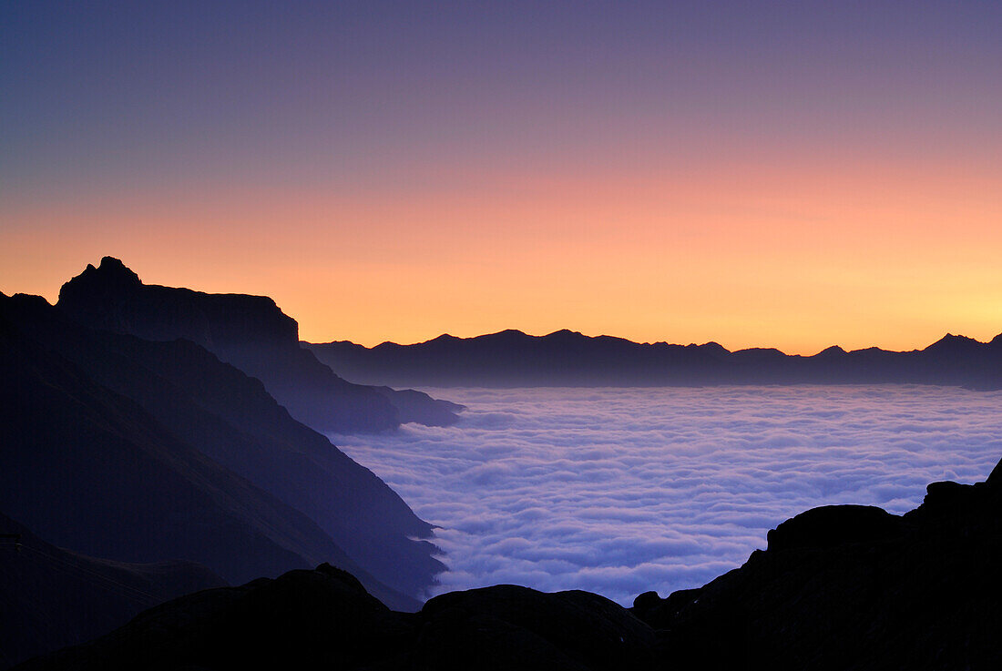 dawn above fog bank in valley Gschnitztal, Kirchdachspitze in background, Bremer Huette, Stubaier Alpen range, Stubai, Tyrol, Austria