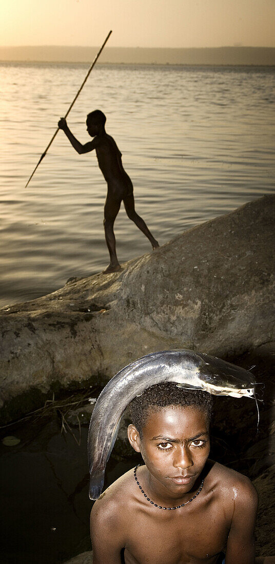 Boy holding fish on his head by Lake Awasa. South Ethiopia. African people