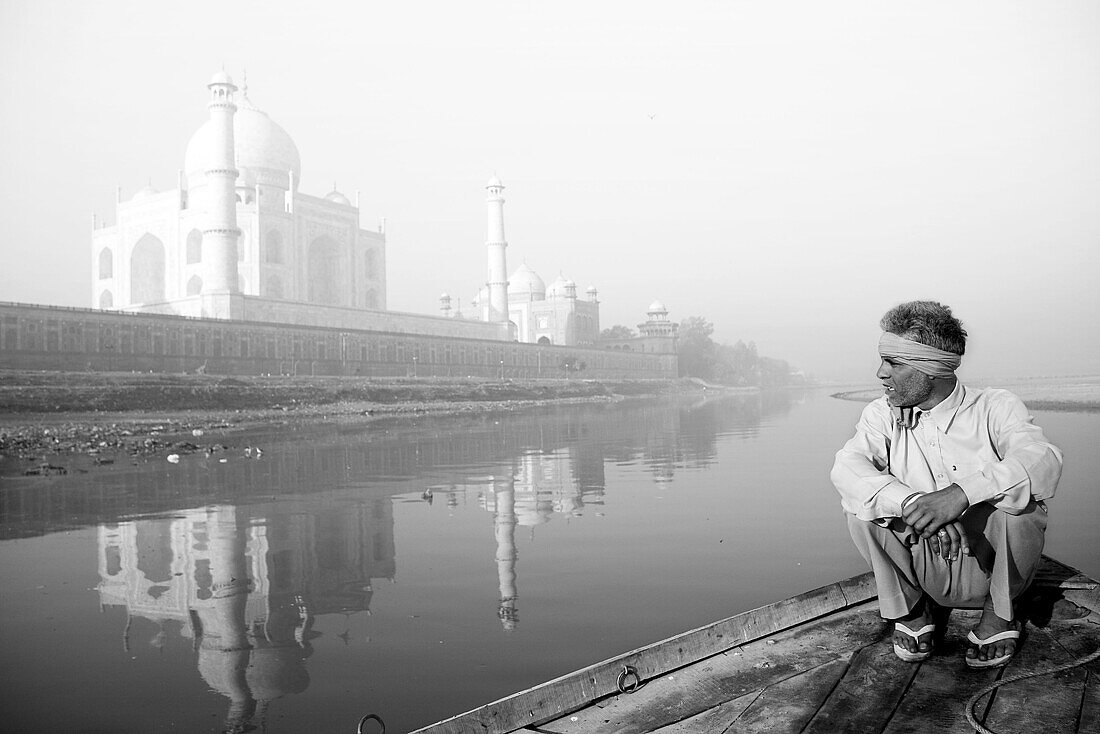 Boatman by Yamuna River with Taj Mahal in background, Agra. Uttar Pradesh, India