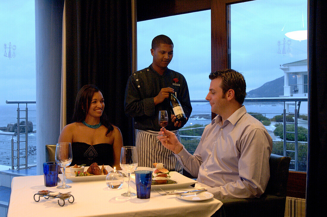 Ein Paar sitzt an einem Tisch, ein Kellner serviert Wein, Restaurant Azur, The Twelve Apostles Hotel, Kapstadt, Südafrika, Afrika