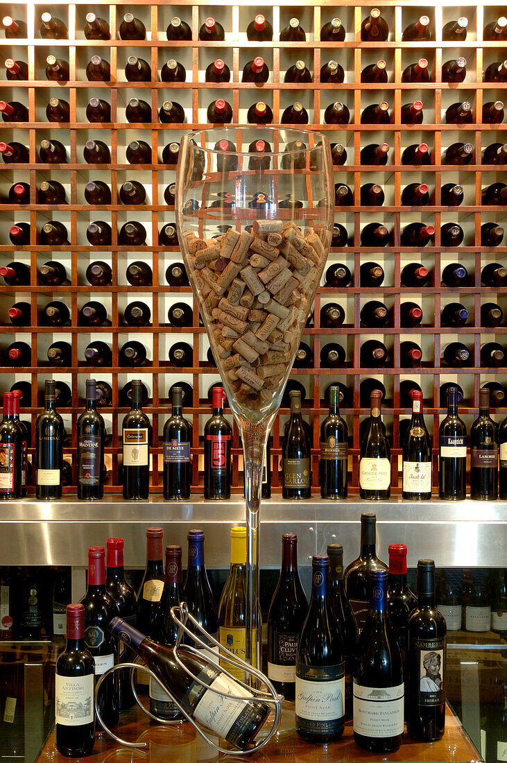 Well-stocked wine rack and a glass filled with corks at the Restaurant Azur, The Twelve Apostles HotelSouth Africa, Africa