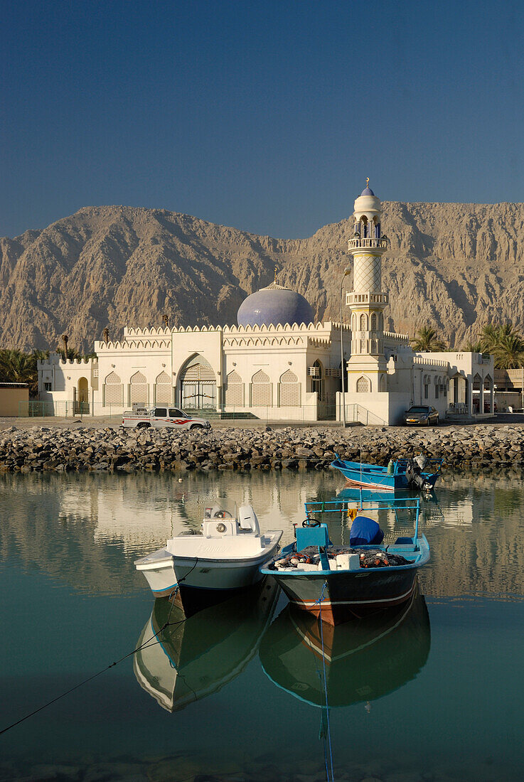 Blick auf Fischerboote im Hafen und eine Moschee im Sonnenlicht, Khasab, Musandam, Oman, Asien