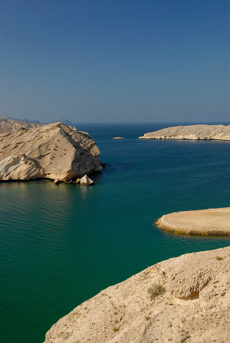Menschenleere Felsenküste unter blauem Himmel, Oman, Asien