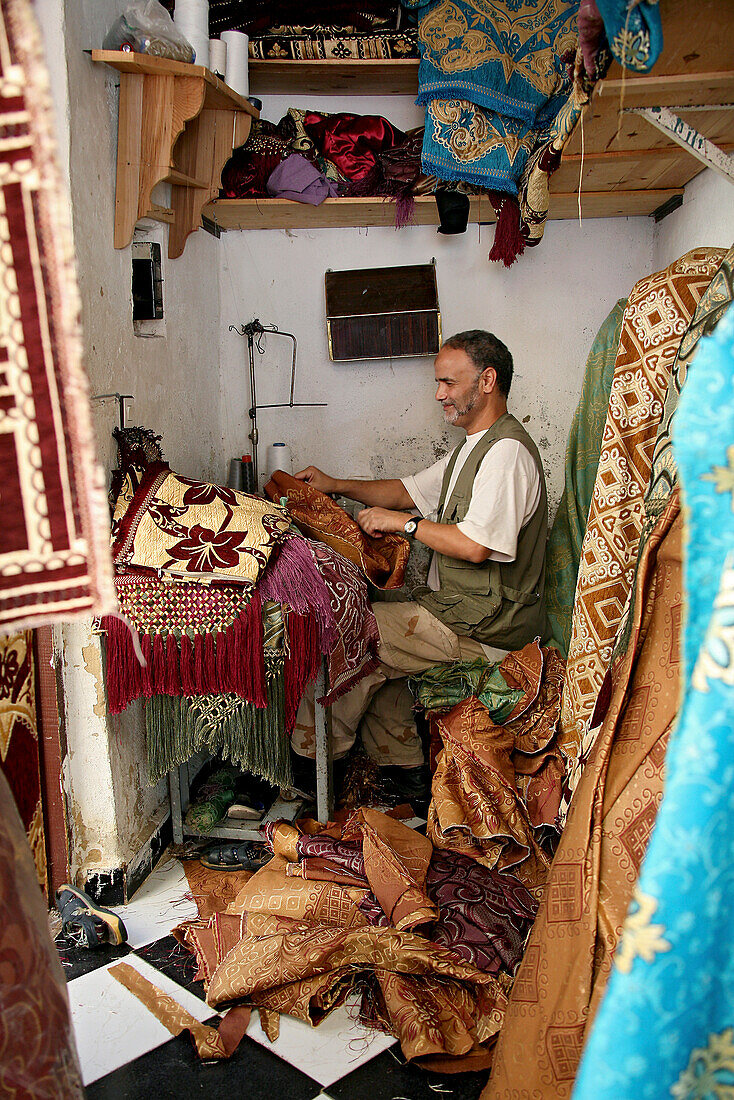 A tailor at his workshop at the medina of Fes, Morocco, Africa