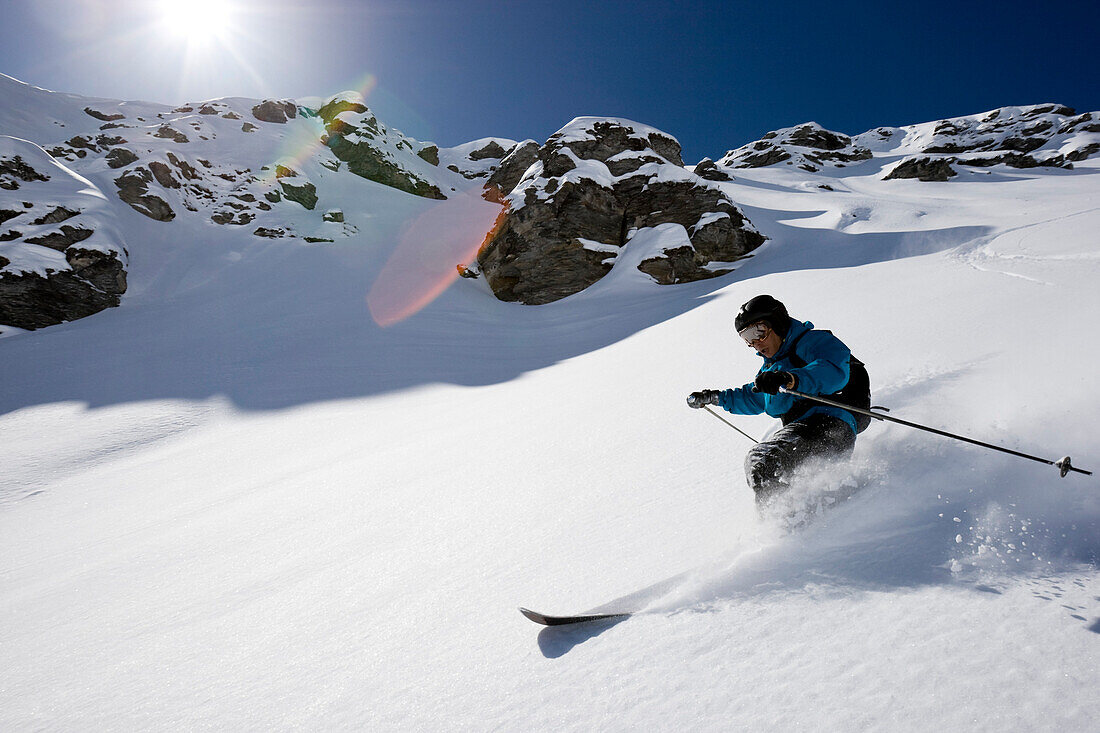 Domaine de Freeride, Zinal, Ein junger Mann mit Telemark Skis zieht seine Kurven im Tiefschnee, Wallis, Valais, Schweiz, Alpen, Freeride, MR