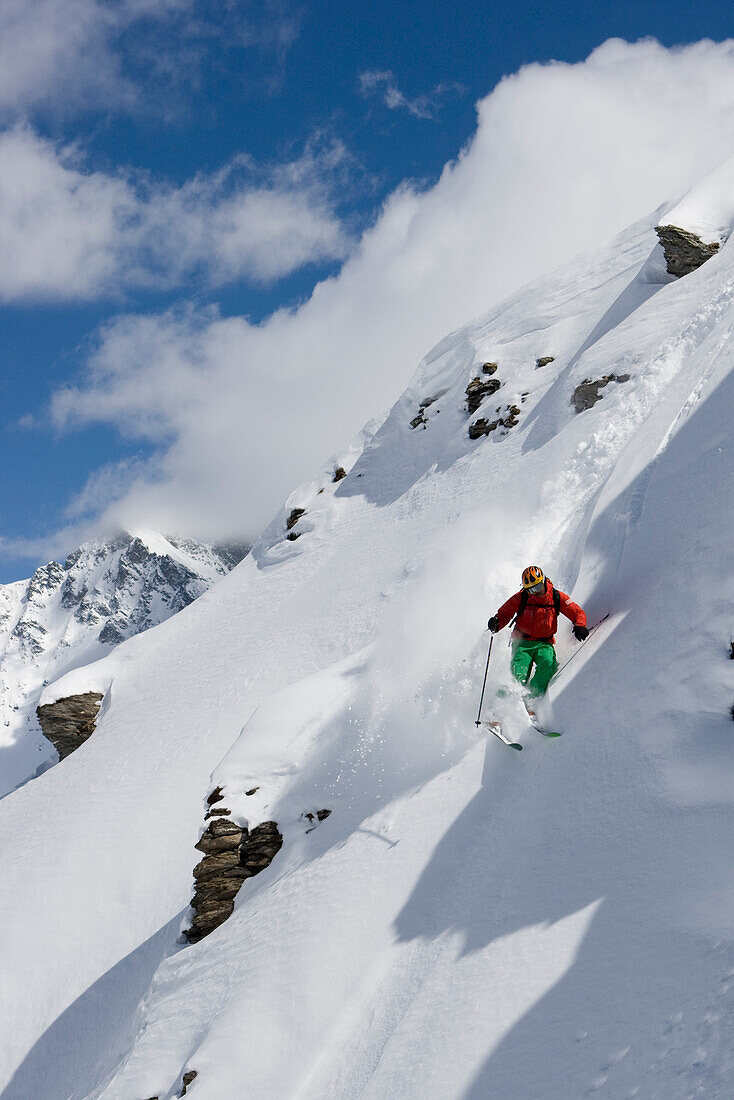 Zinal, Domaine de Freeride, Ein junger Mann, ein Skifahrer, ein Freerider fährt einen Steilhang im Tiefschnee, Wallis, Valais, Schweiz, Alpen, MR