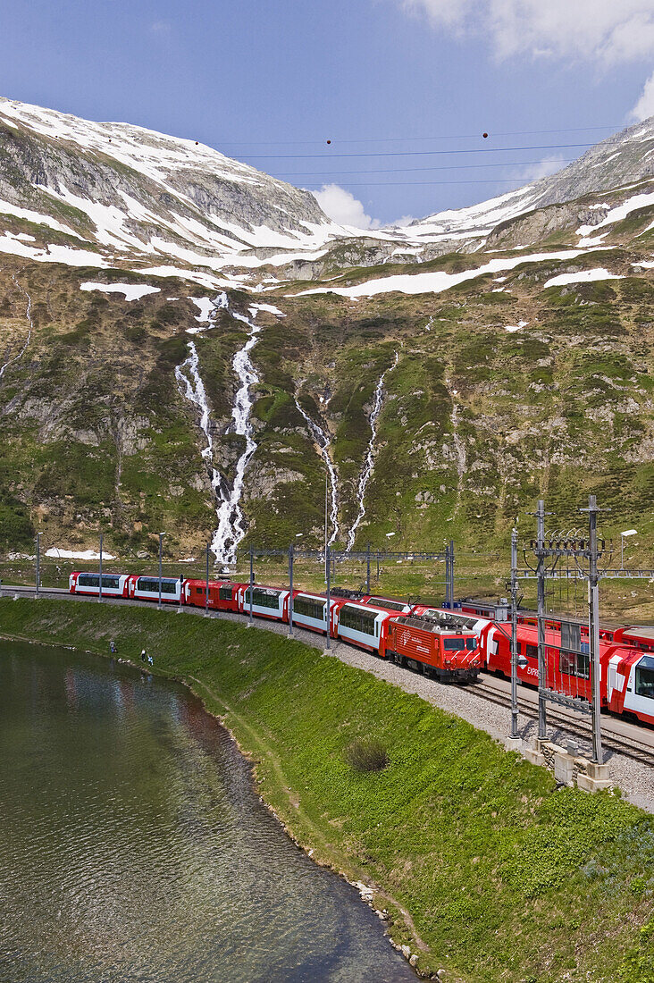 Zug fährt am See vorbei, Berglandschaft, Furka Pass, Schweiz