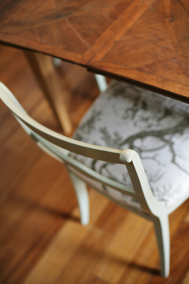 Antiker weisser Stuhl und Tisch auf einem Parkettboden