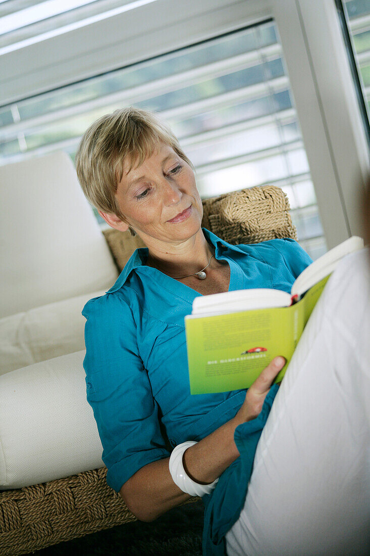 Mature woman reading a book, Styria, Austria