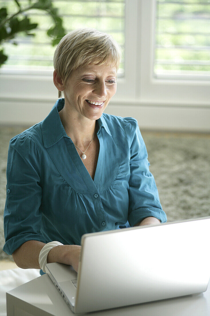 Ältere Frau arbeitet an Laptop