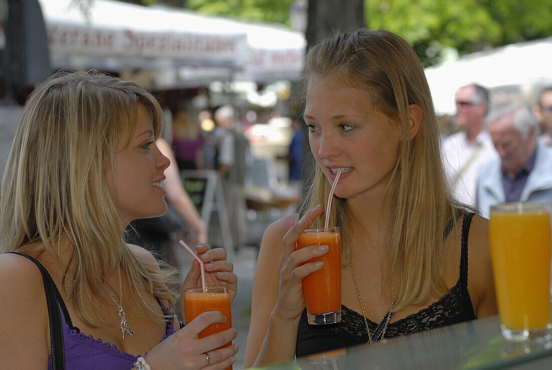 Zwei junge Frauen trinken frischen Saft, Viktualienmarkt, München, Bayern, Deutschland