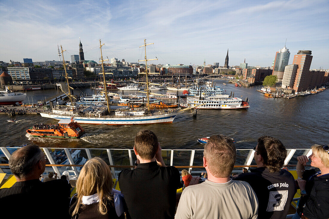 Passengers on cruise ship AidaDiva looking at ships at harbour, Hamburg, Germany