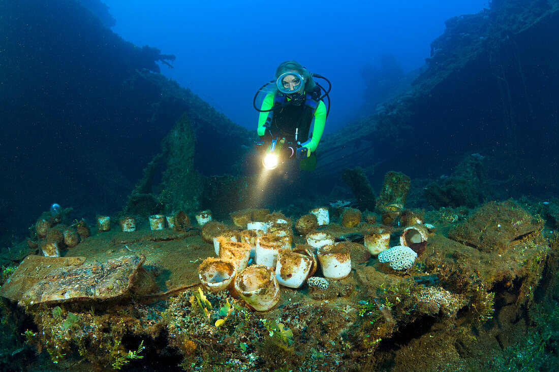 Taucher findet Geschirr und Artefakte auf der USS Saratoga, Marschallinseln, Bikini Atoll, Mikronesien, Pazifik