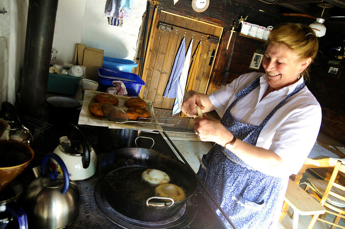 Woman baking fritters, doughnuts, at the Freudenreich lodge on the Brecherspitz, Schliersee, Bavaria, Germany