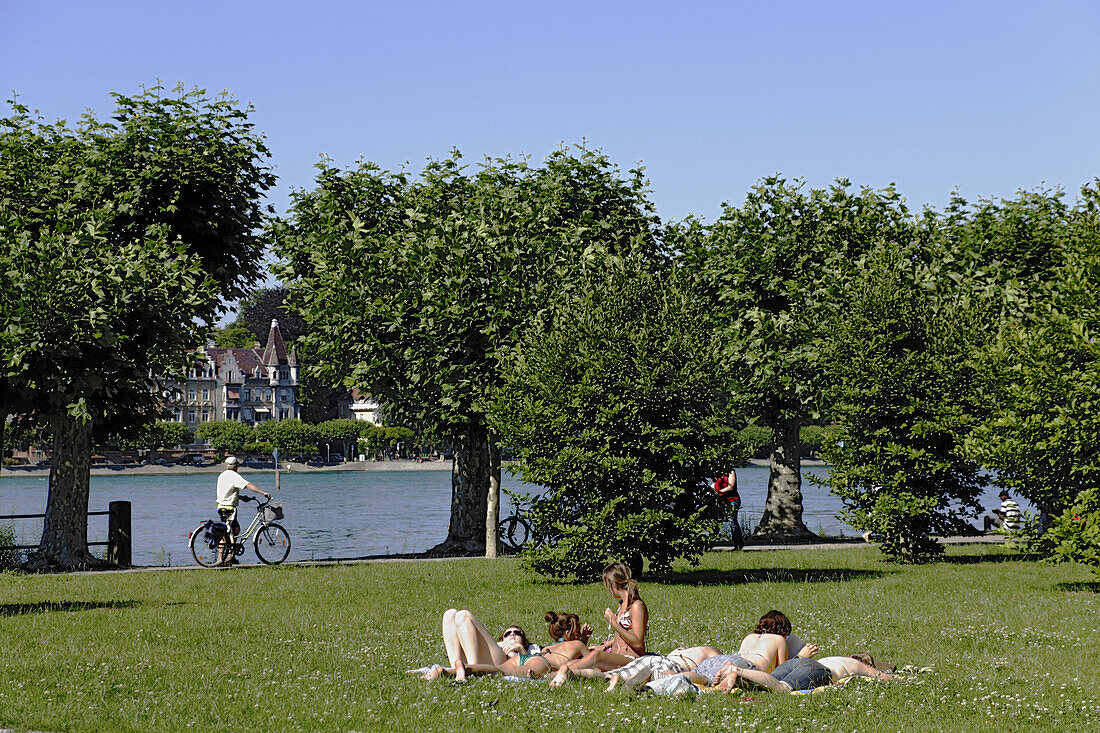Young people sunbathing at Lake Constance, Konstanz, Baden-Wurttemberg, Germany