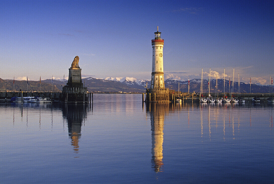 Leuchtturm und Löwenskulptur an der Hafenausfahrt, verschneite Alpen im Hintergrund, Lindau, Bodensee, Baden-Württemberg, Deutschland