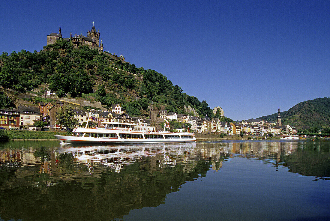 Reichsburg unter blauem Himmel und Ausflugsschiff auf dem Fluss, Mosel, Rheinland-Pfalz, Deutschland