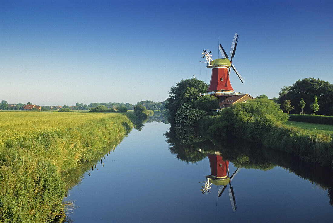 Windmühle spiegelt sich im Kanal, Greetsiel, Ostfriesland, Niedersachsen, Deutschland