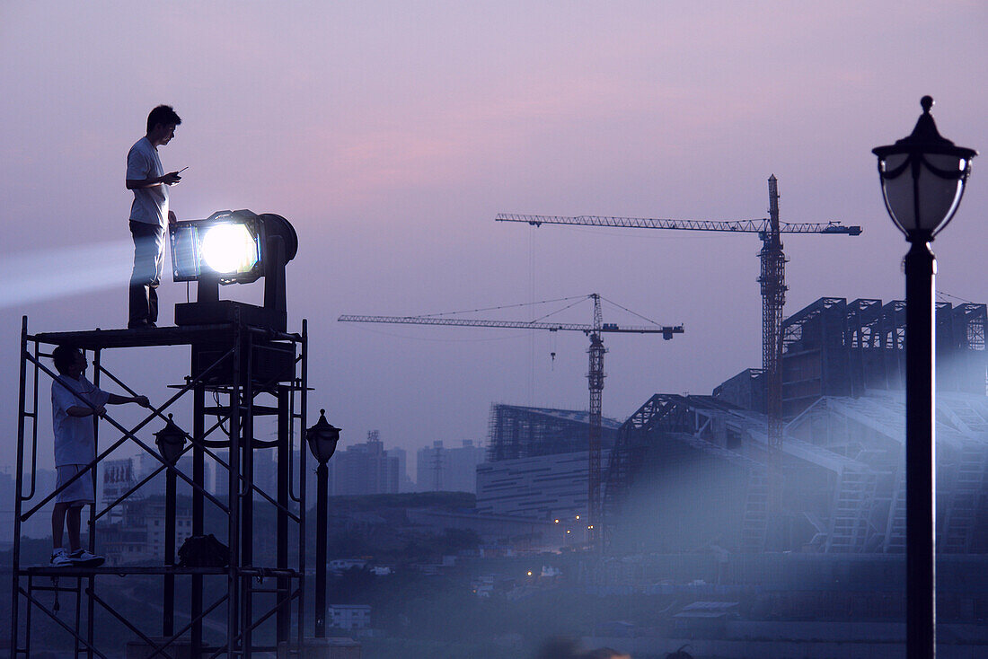 Two illuminators in the attitude of a floodlight on a scaffolding, Chongqing, China, Asia