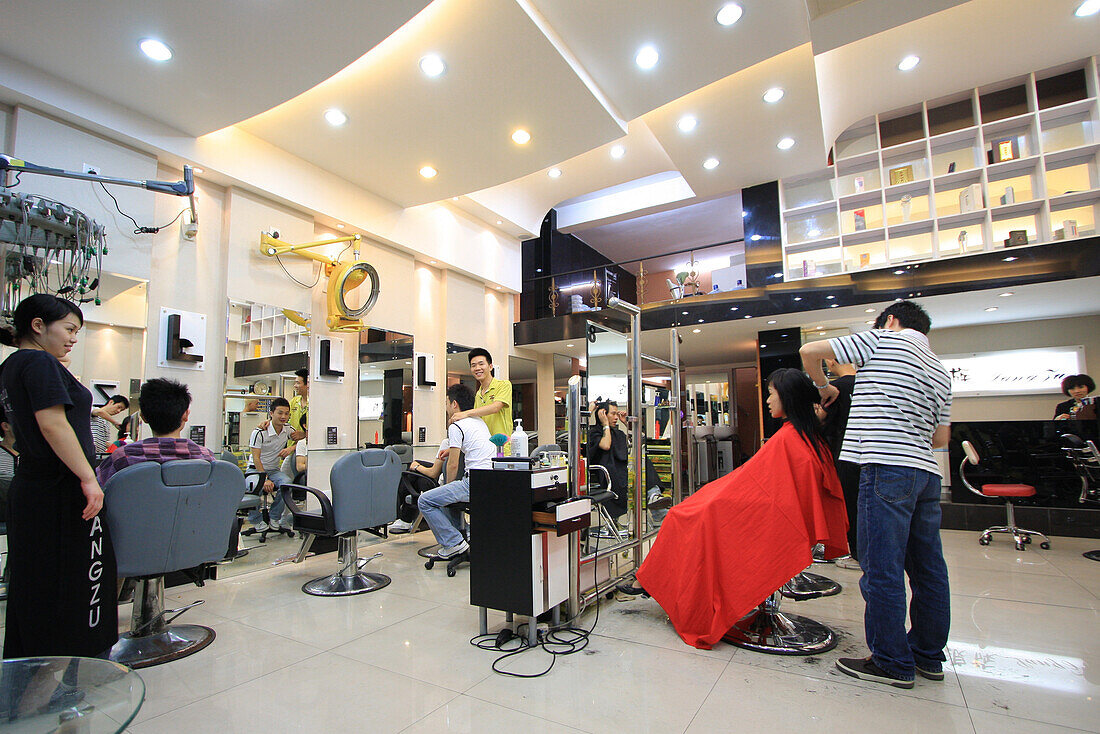Moderner Frisörsalon mit Hairstylisten und Kunden in Chongqing, China, Asien