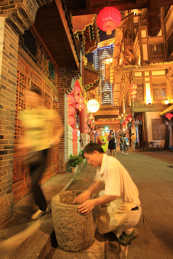 Der Koch sucht den verlorenen Geldschein im Müll in der Hongyadong Folklore Mall, Chongqing, China, Asien