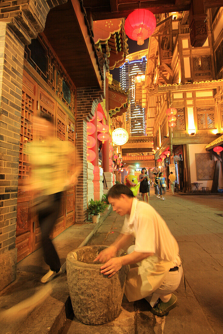 The cook searches for the lost bill in the trash at the Hongyadong Folklor Mall, Chongqing, China, Asia