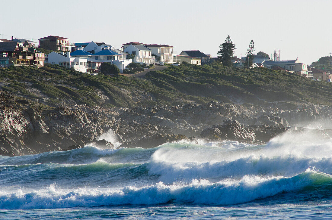 Waves and houses above the cliffs at Walker Bay, Gansbaai, Western Cape, South Africa, Africa