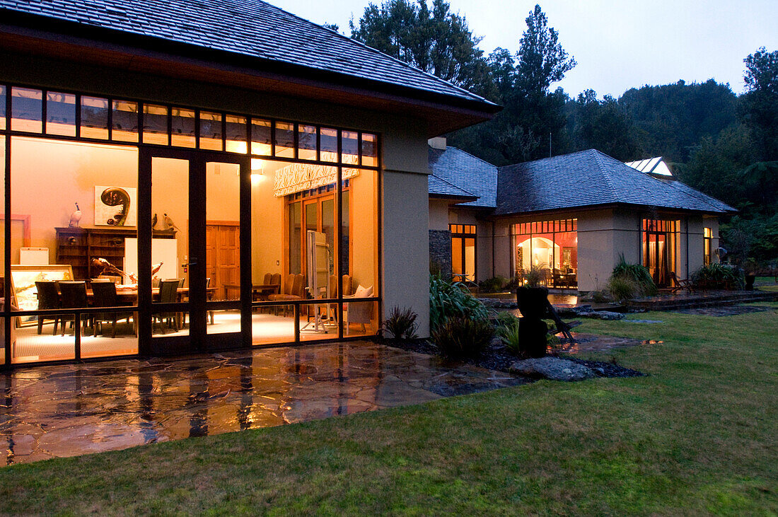 View at the illuminated windows at the Treetops Lodge in the evening, North Island, New Zealand, Oceania