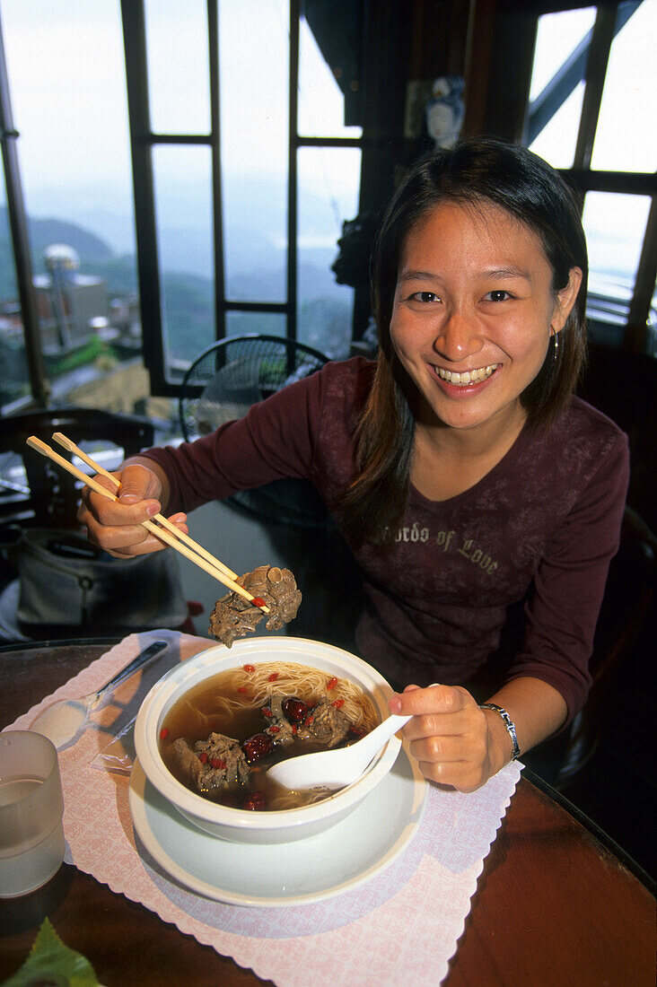 Lachende Frau beim Essen in einem Restaurant in Chiufen, Taiwan, Asien