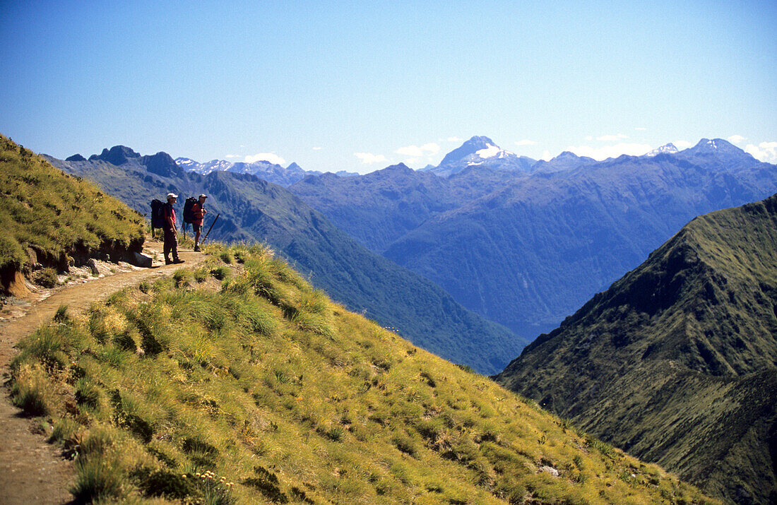 Zwei Trekker am Kepler Track betrachten die Aussicht auf die Berge im Fiordland Nationalpark, Südinsel, Neuseeland, Ozeanien