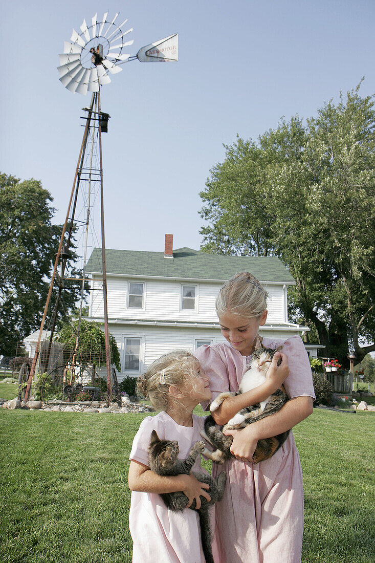 Amish Farm Tour, girls, sisters, cat, kitten, house, windmill. Shipshewana. Indiana. USA.
