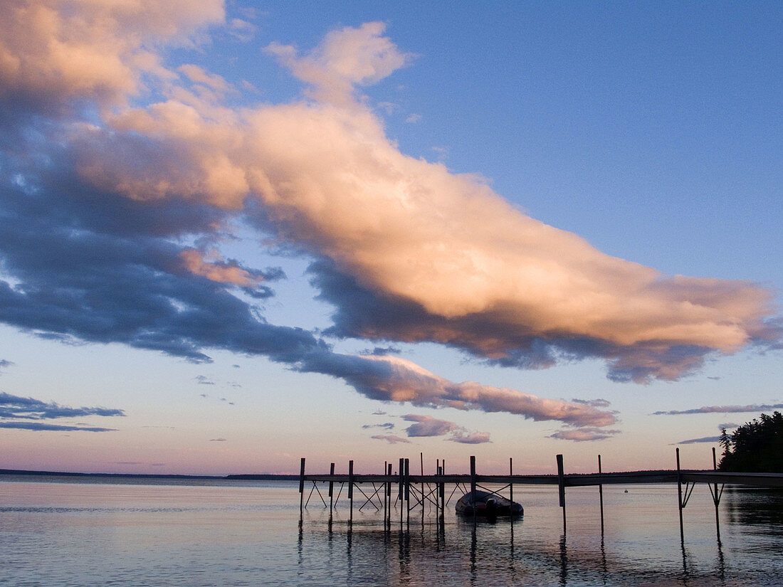 Small dock with boat at sunset in Sebago Lake, Maine