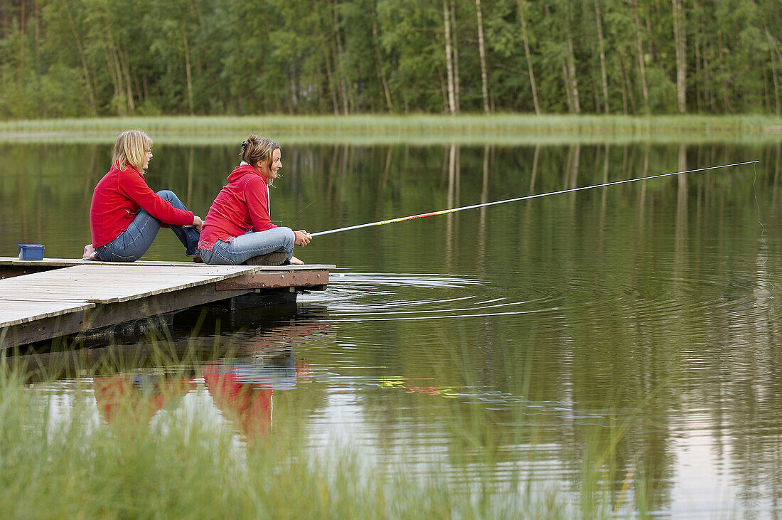 Three persons fishing on a jetty, Vasterbotten, Sweden (July 2005)