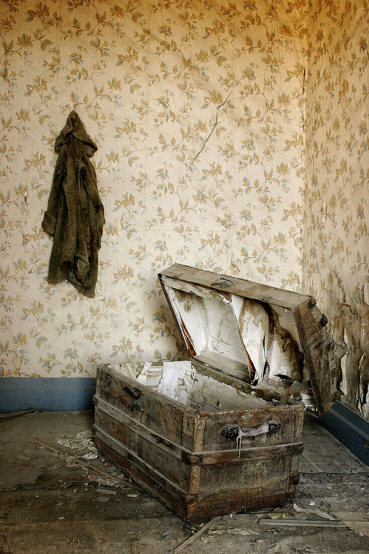 A coat hangs on the wall above an open trunk in a Bodie residence, CA, USA