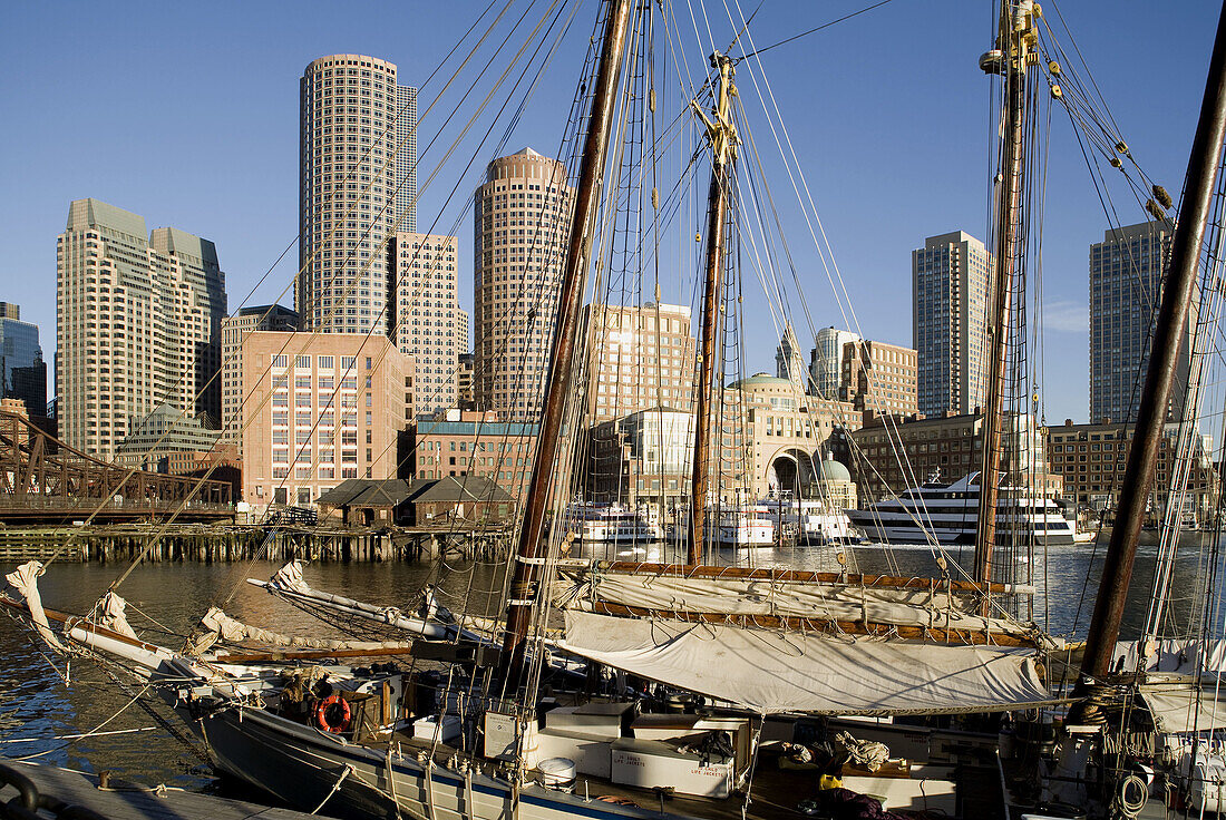 Harbor sunrise from water, two antique schooners foreground, Rowes Wharf and International Place in backgroound, Boston, Usa.