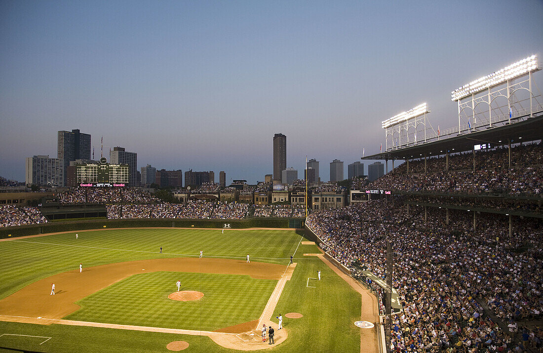 Crowd in stands watching night game at Wrigley Field, stadium for Chicago Cubs professional baseball team, diamond  Chicago, Illinois, USA