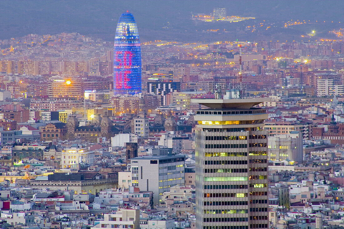 View of Barcelona at dusk with the Torre Colom in the foreground and Agbar Tower by architech Jean Nouvel at the background. Barcelona. Spain