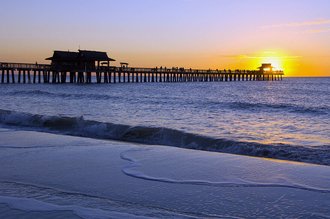 Sunset over the Gulf of Mexico and the pier at Naples Beach, Florida, USA