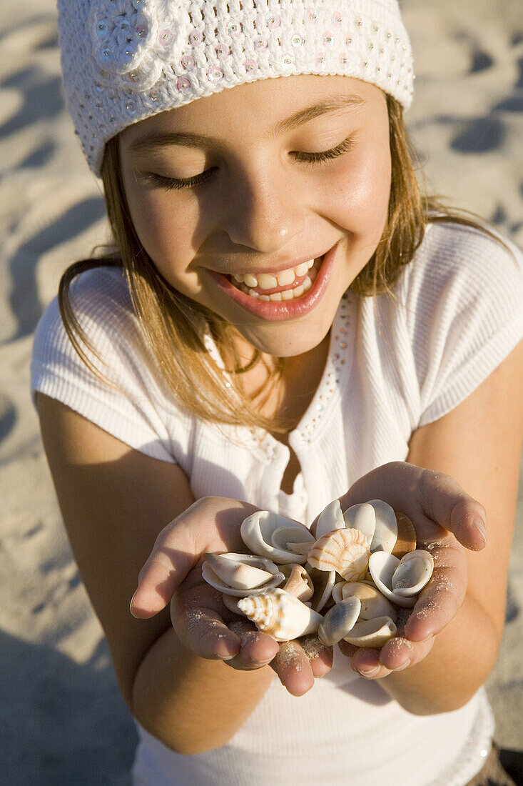 Girl with handsful of  seashells