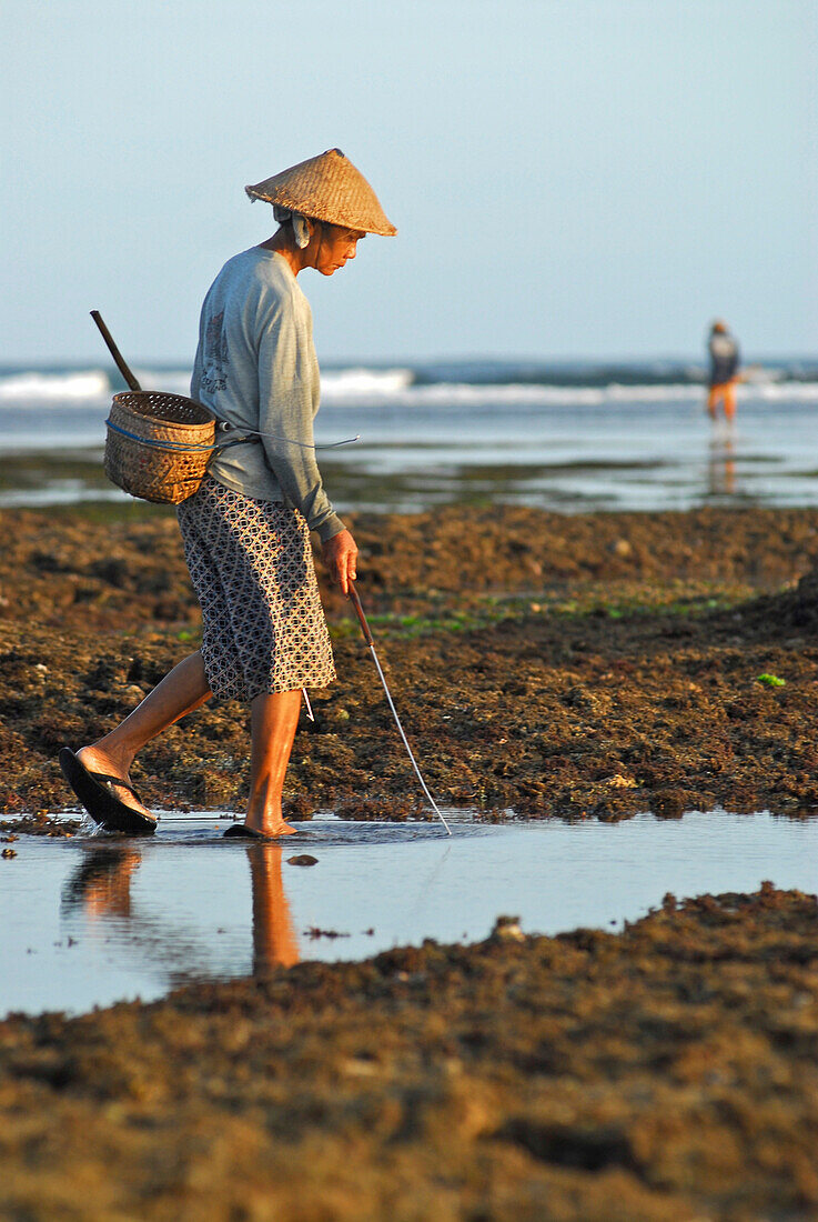 Ein Fischer bei Ebbe am Strand, Pura Geger, Süd Bali, Indonesien, Asien