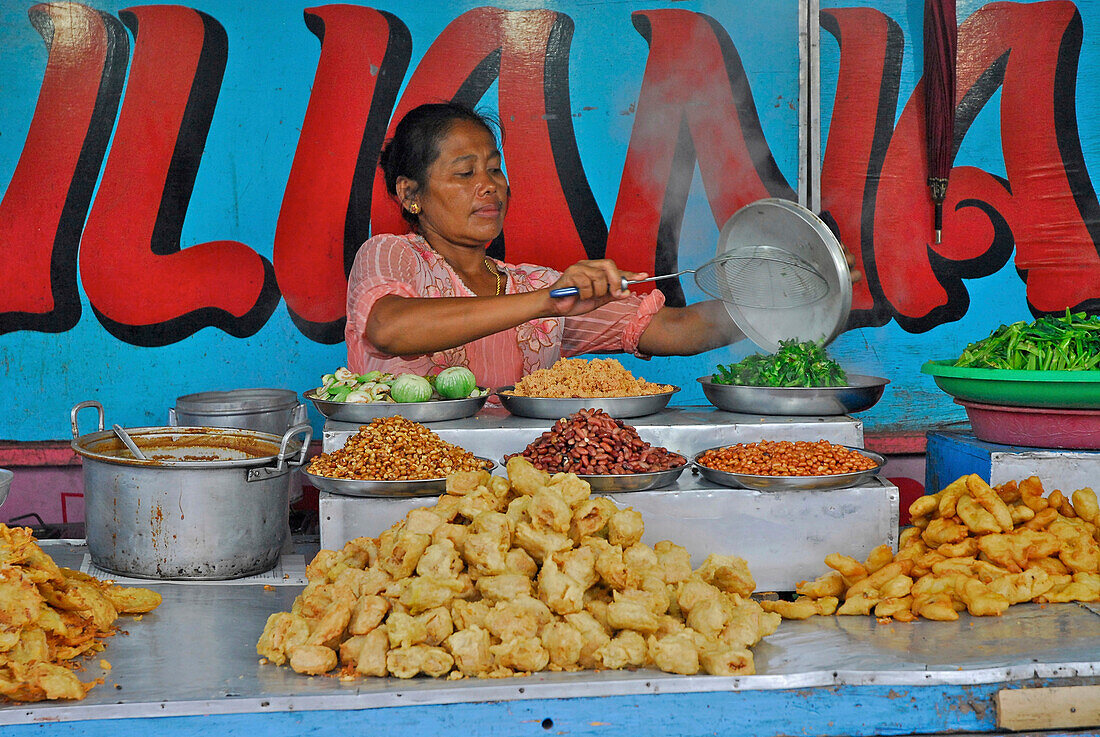 Ältere Frau bereitet Essen in einem Imbiss, Pura Samuan Tiga, Bali, Indonesien, Asien