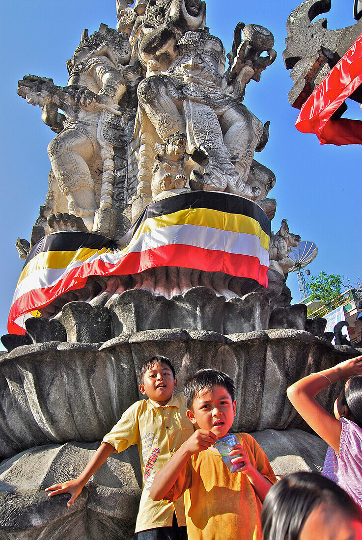 Kinder vor einem Denkmal unter blauem Himmel, Klungkung, Bali, Indonesien, Asien