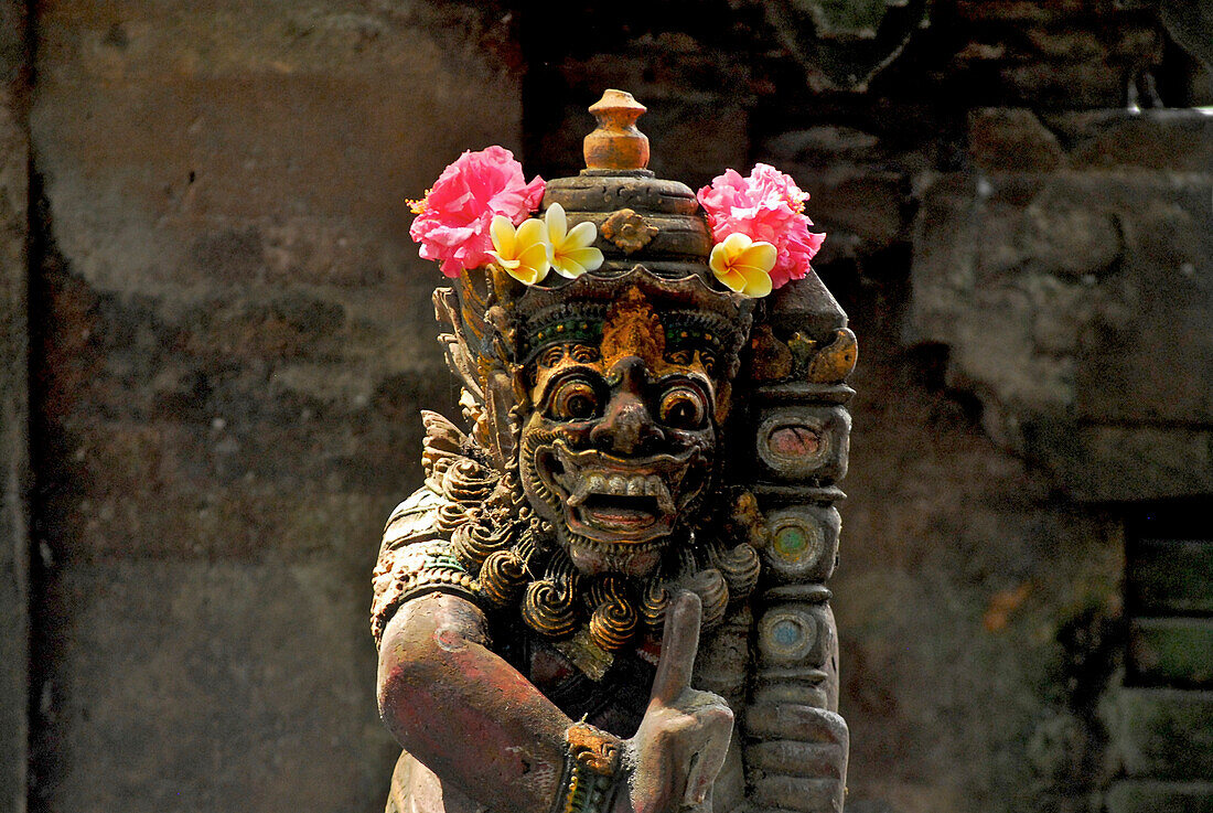 Figur mit Blumen in einem Tempel, Ubud, Zentral Bali, Indonesien, Asien