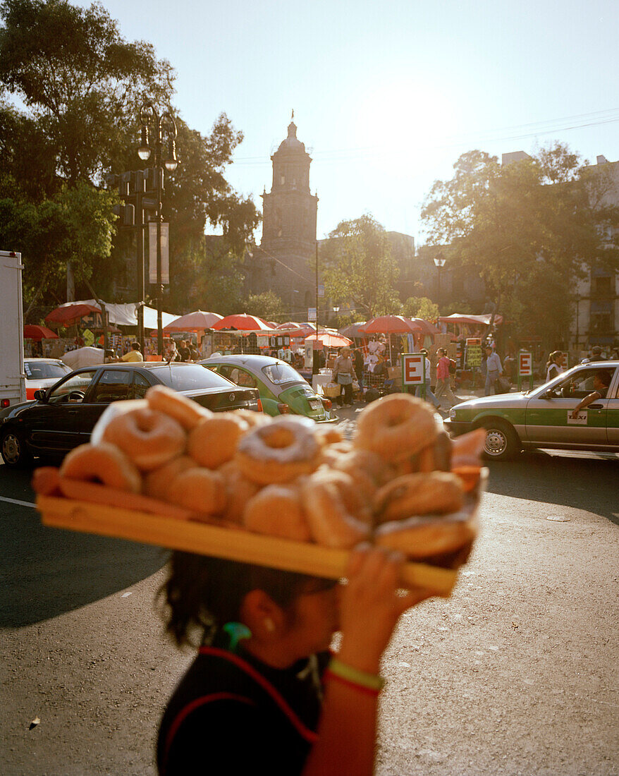 Blick auf einen kleinen Markt an der Kirche Pina Suarez, Frau mit einem Tablett voller Krapfen, Mexico City, Mexico, Amerika